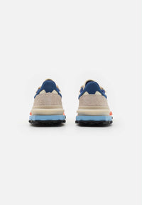 Basket Lacoste Elite Active en coloris écru et marine