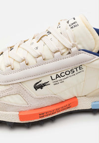 Basket Lacoste Elite Active en coloris écru et marine